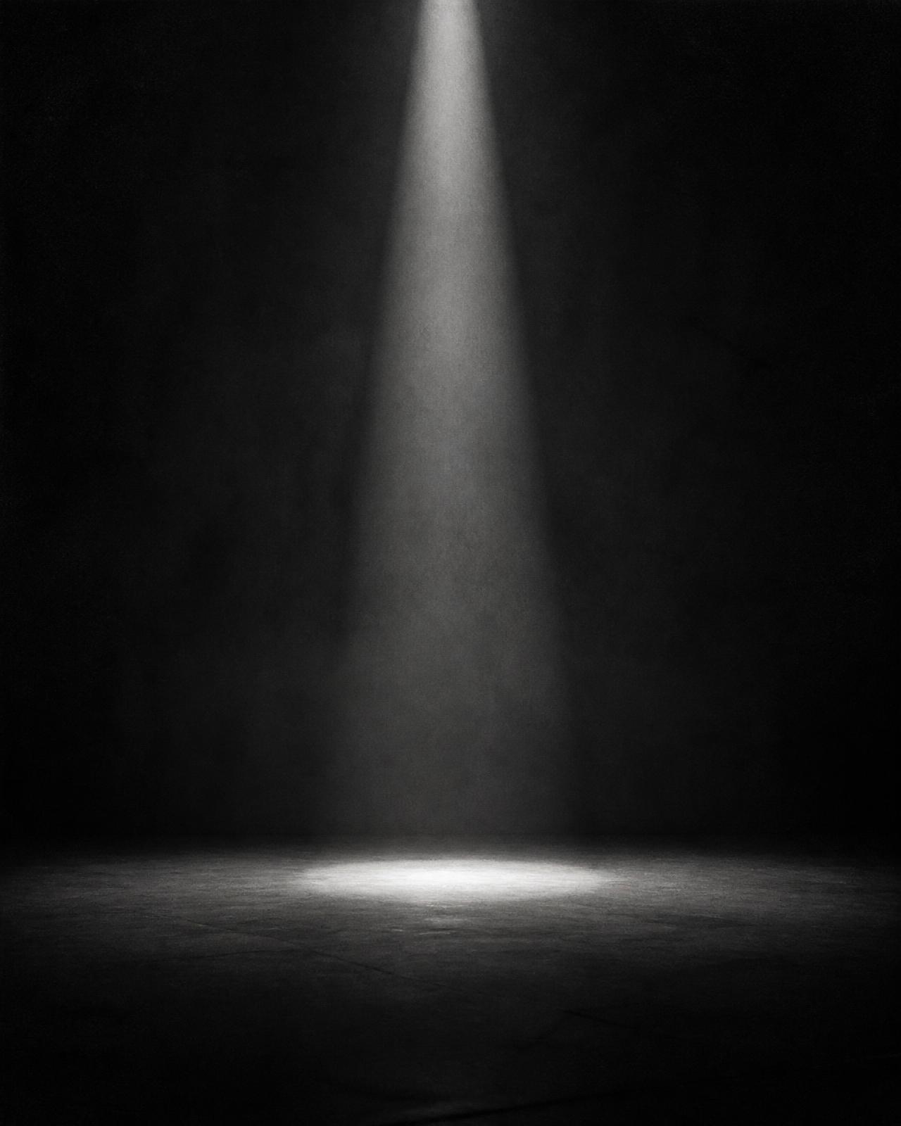 A single shaft of light falling into a dark empty room